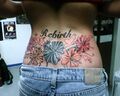 This girl's tramp stamp featuring half dead flowers and heart doodles.