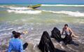 Women in burqas enjoy the beach.